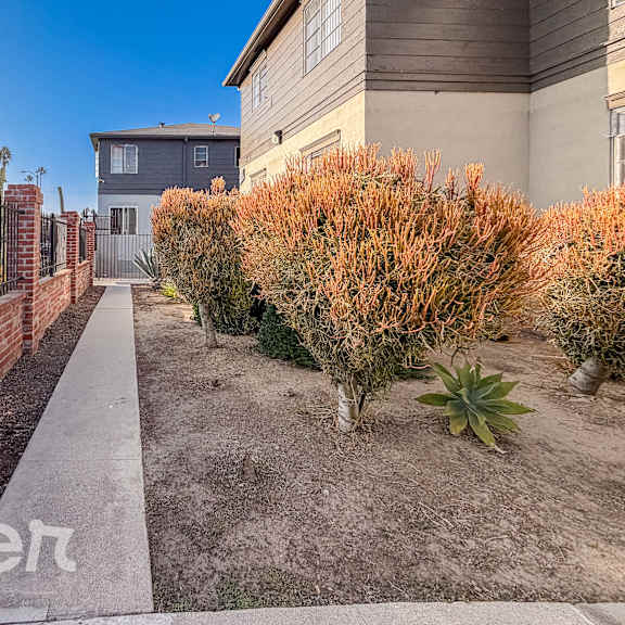 a residential area with a house, a fence, and a sidewalk.