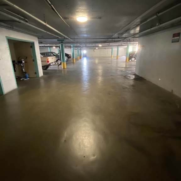 a dirty industrial hallway with a light on the left side.