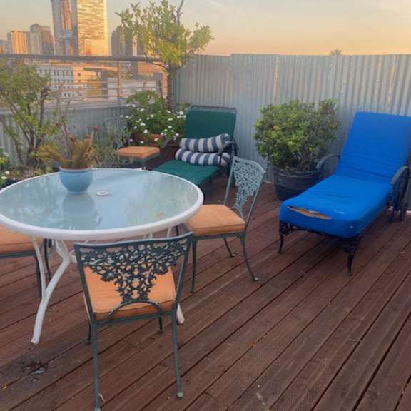 a wooden deck with a table, chairs, and plants.