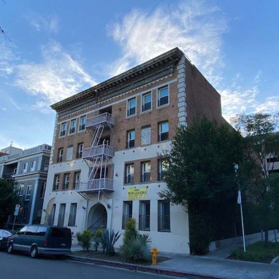 a building with a sign that says "for rent" is on the corner of a street.