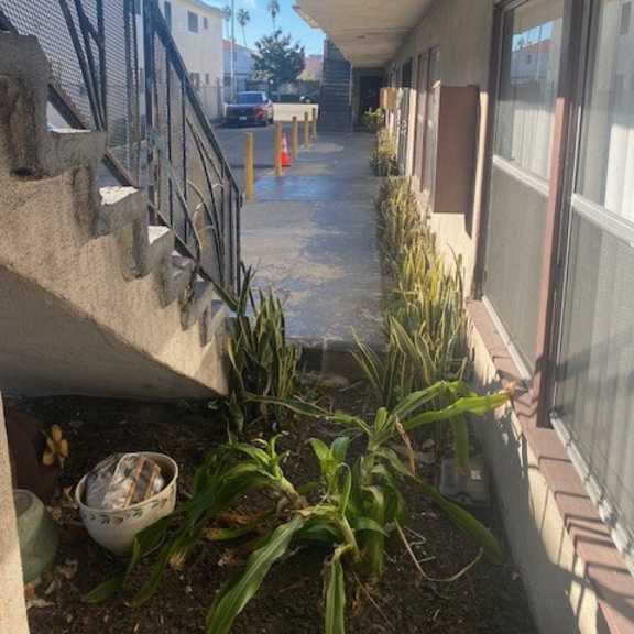 a concrete staircase with a metal railing on the left side and a concrete wall on the right side with a window.