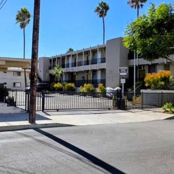 a street view of a residential area with a house and apartment buildings.