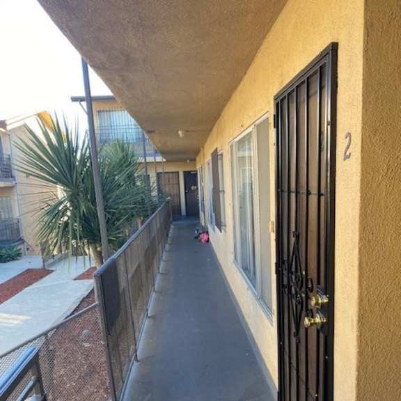 a long hallway with a black gate at the end.