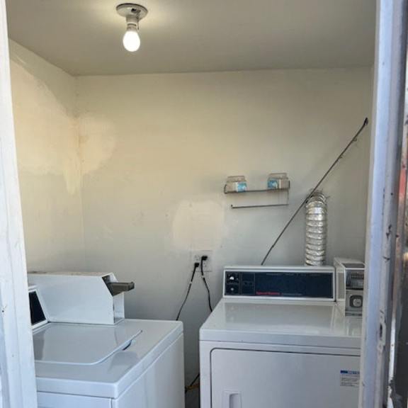 a white washing machine and dryer in a small room.