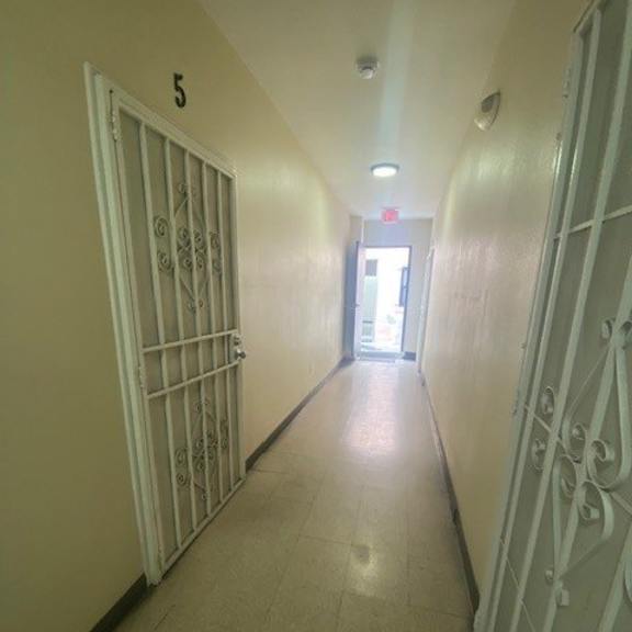 a long hallway with doors on both sides and a number 5 on the wall.