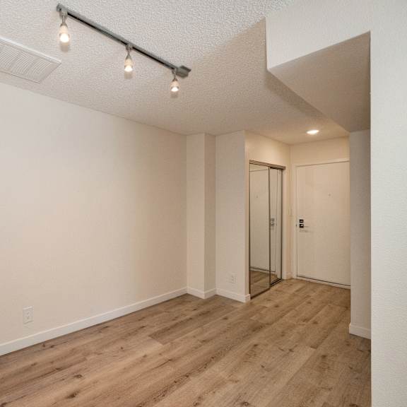 a bedroom with hardwood floors and white walls at croft plaza apartments, west hollywood