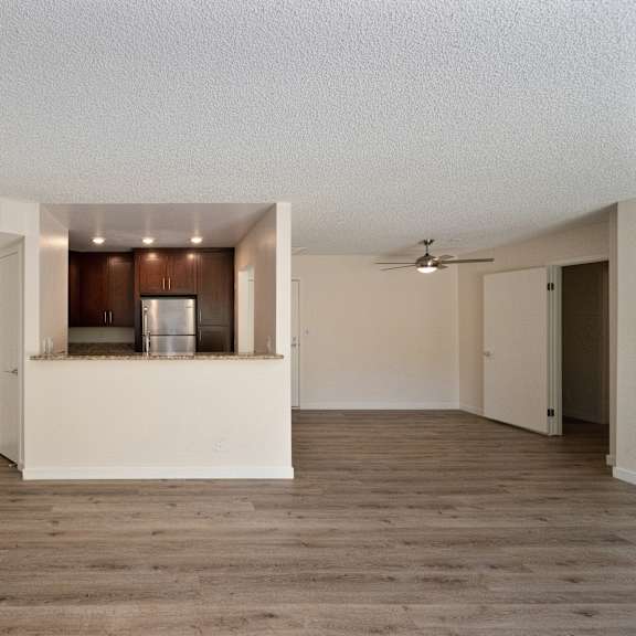 an empty living room with a kitchen in the background at croft plaza apartments, west hollywood california