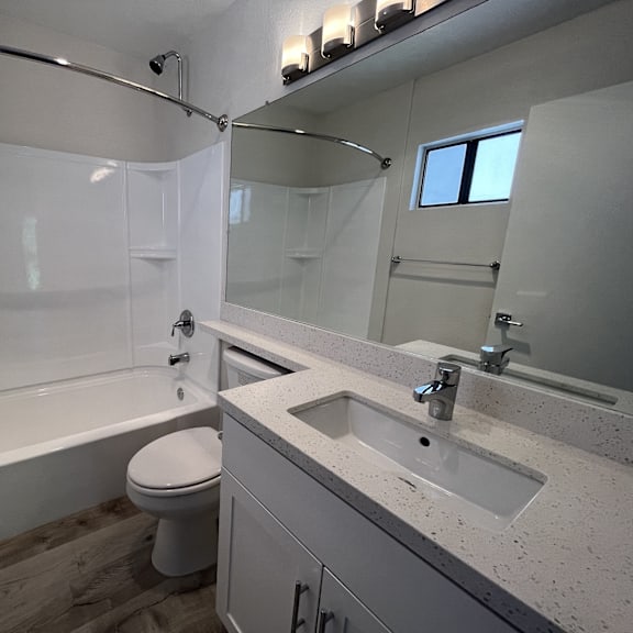 Thumbnail 7 of 7 A white toilet sits in a bathroom next to a sink.