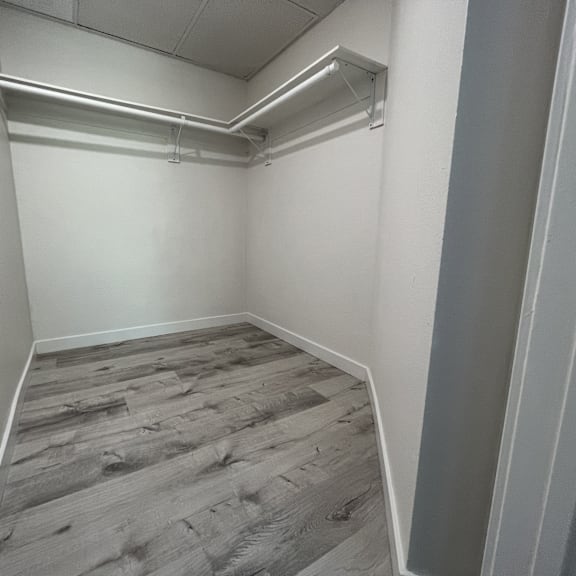 Thumbnail 6 of 7 A room with wooden flooring and white walls.