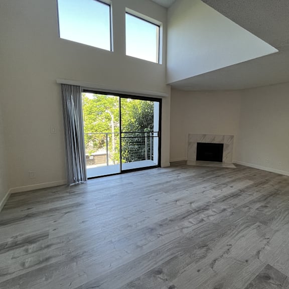Thumbnail 4 of 7 A spacious room with a fireplace and sliding glass doors.