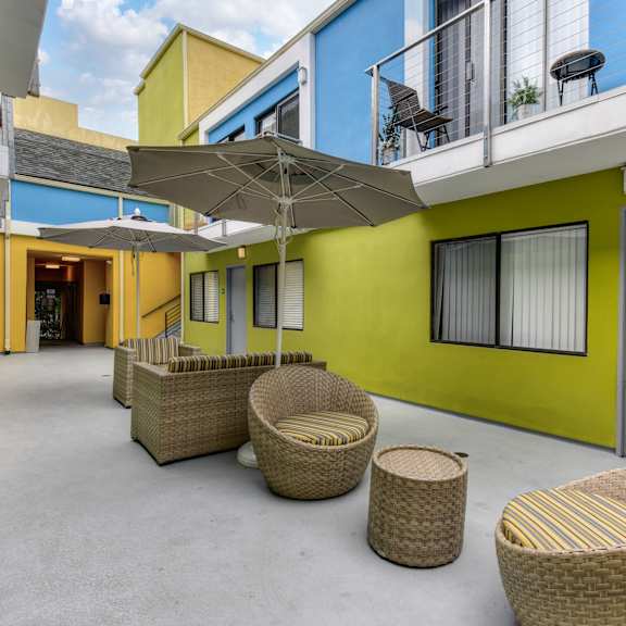 sitting area in the center of the community. there are wicker chairs, tables and umbrellas for the residents comfort.at croft plaza apartments, west hollywood, ca 90069