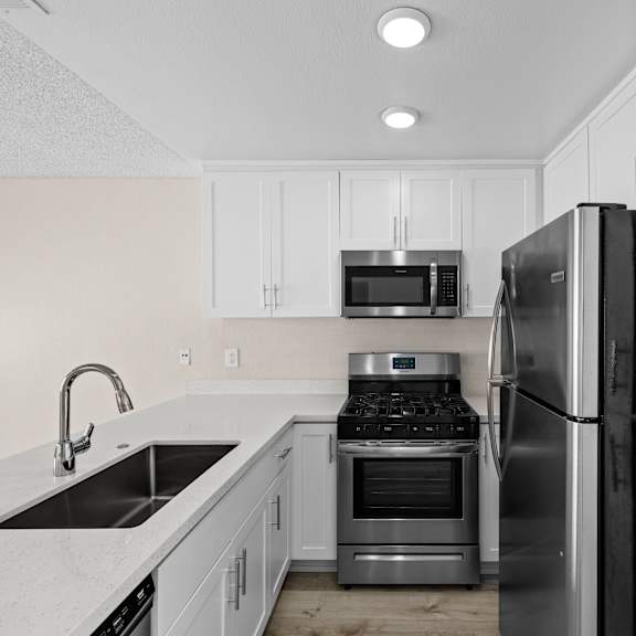 a modern kitchen with a sink, stove, and refrigerator.