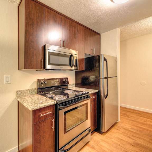 kitchen with wood inspired floors, oven, microwave and refrigerator at the retreat at walnut creek, walnut creek, ca