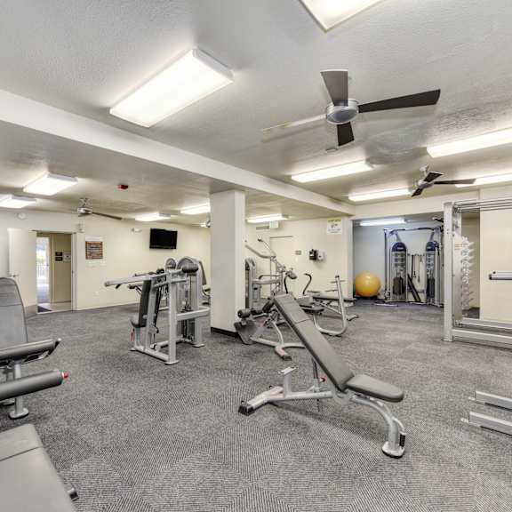 the retreat's fitness center with multiple weight systems & cardio equipment.  large room that is well-lit and with ceiling fans. at the retreat at walnut creek, california, 94596