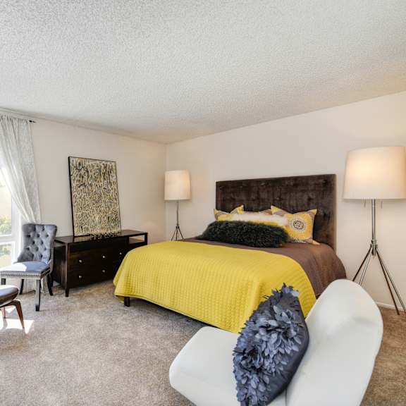 a bedroom with a large window and yellow bedspread at the retreat at walnut creek, walnut creek, california