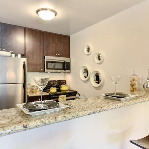 a kitchen with granite countertops and stainless steel appliances at the retreat at walnut creek, walnut creek, california