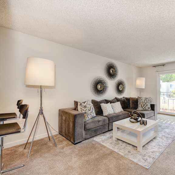 a living room with a couch coffee table and a sliding glass door at the retreat at walnut creek, walnut creek