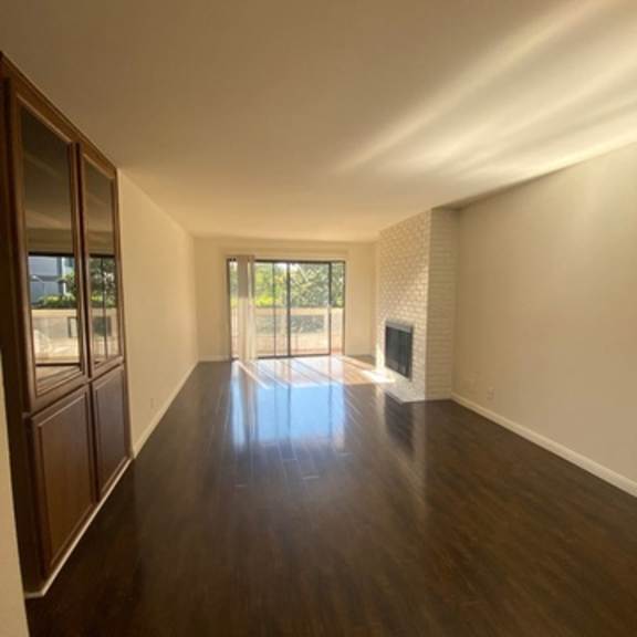 Thumbnail 10 of 10 A long, empty hallway with wood floors and white walls.