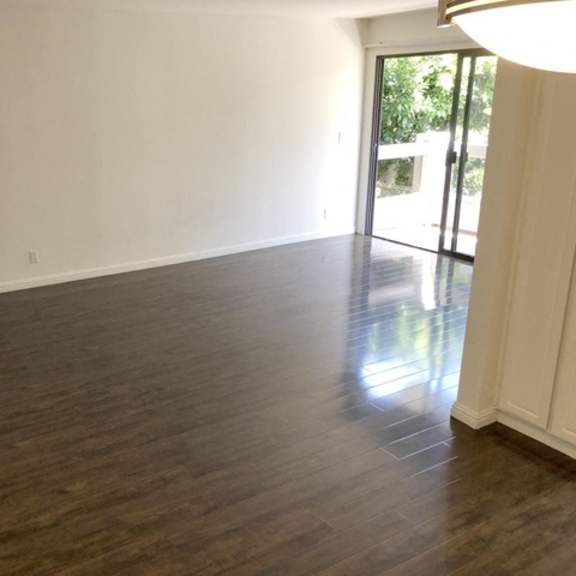 Thumbnail 19 of 33 A room with wooden flooring and a sliding glass door.