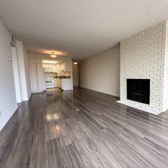 Thumbnail 20 of 25 A room with a fireplace and wood flooring.
