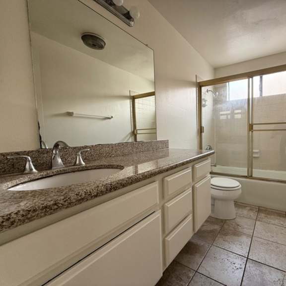Thumbnail 22 of 25 A bathroom with a sink, toilet, and shower.
