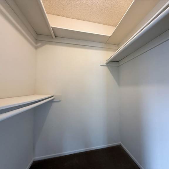 Thumbnail 25 of 25 A white closet with a shelf and a white door.