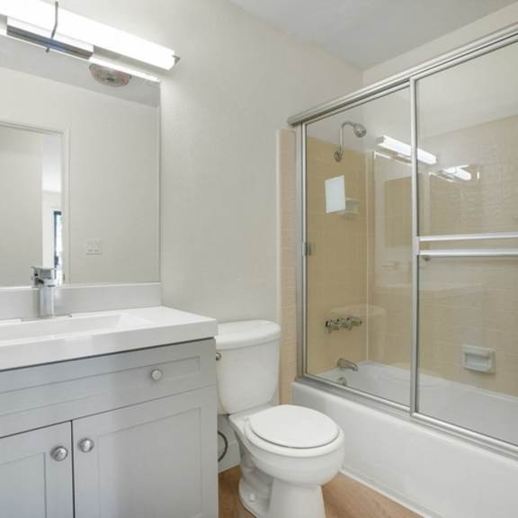 Thumbnail 26 of 31 A white bathroom with a toilet, sink, and shower.