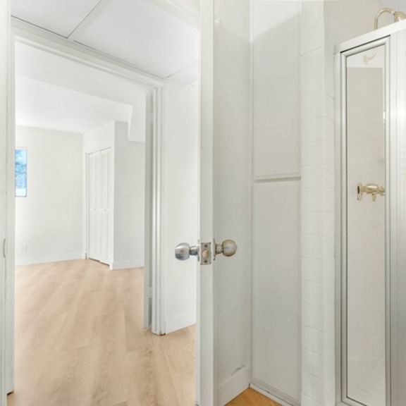 Thumbnail 28 of 31 A white door with a gold handle is in a white room.