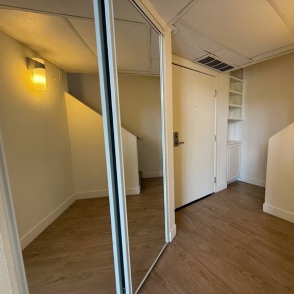 Thumbnail 8 of 17 A hallway with a mirror on the left side.