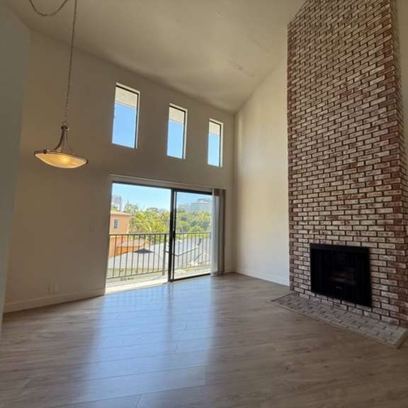 Thumbnail 17 of 17 A room with a fireplace and a sliding glass door.