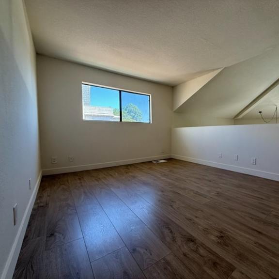 Thumbnail 3 of 17 A room with wooden flooring and a window.