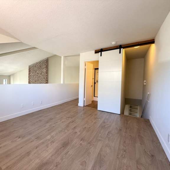 Thumbnail 13 of 17 A room with wooden flooring and white walls.