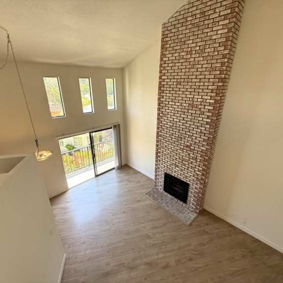 Thumbnail 11 of 17 A room with a fireplace and a brick wall.
