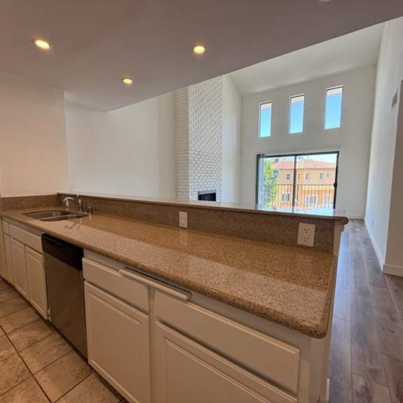 Thumbnail 3 of 20 A kitchen with a sink, countertop, and cabinets.
