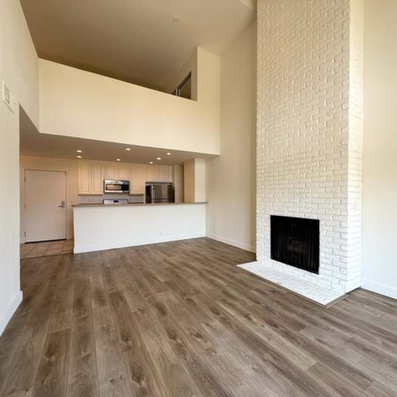 Thumbnail 12 of 20 A modern living room with a fireplace and wooden flooring.