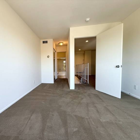 Thumbnail 11 of 20 A room with a carpeted floor and white walls.