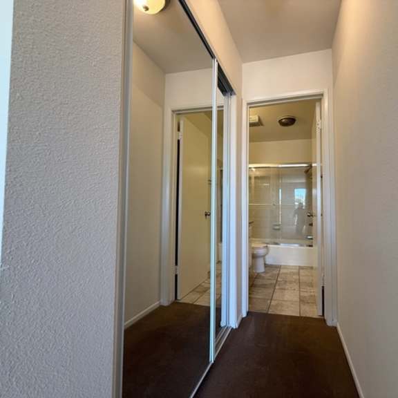 Thumbnail 13 of 20 A hallway with a toilet and sink visible through the door.