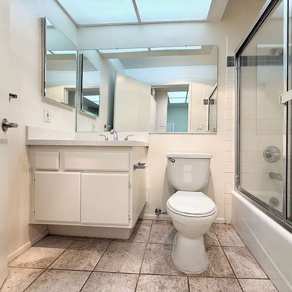 Thumbnail 2 of 39 A white toilet sits in a bathroom with a walk-in shower.