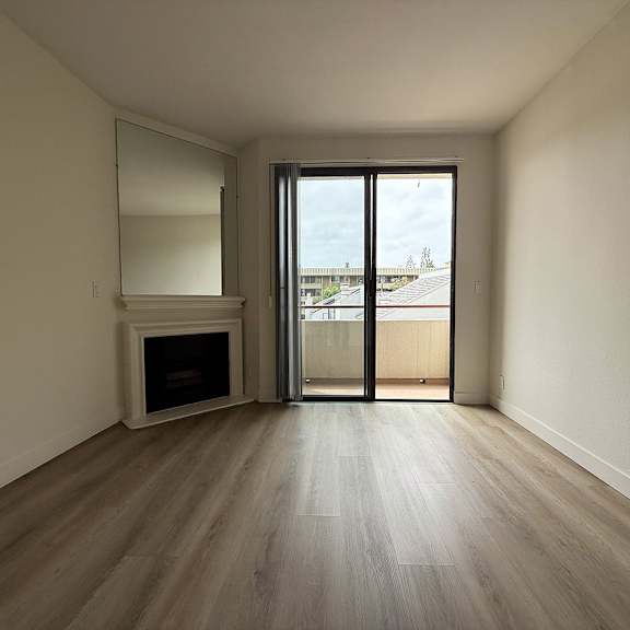 Thumbnail 14 of 29 A room with a fireplace and sliding glass doors.