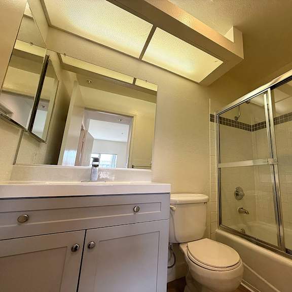 Thumbnail 3 of 29 A bathroom with a toilet, sink, and shower.