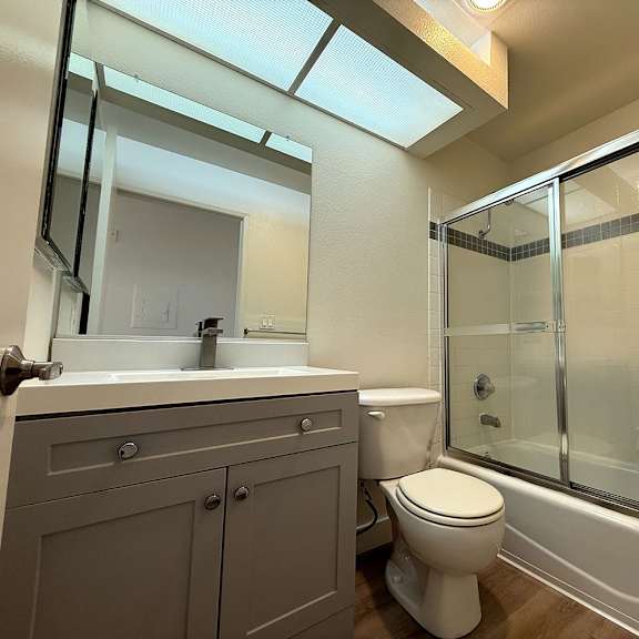 Thumbnail 16 of 29 A bathroom with a toilet, sink, and shower.