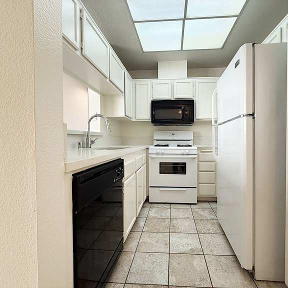 Thumbnail 10 of 53 A kitchen with white appliances and a black oven.