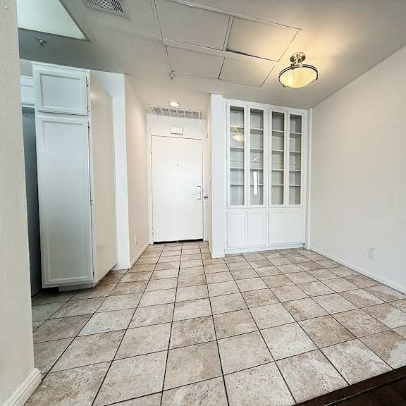Thumbnail 6 of 53 A room with a tiled floor and a ceiling light.