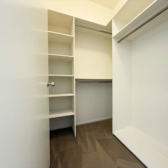 Thumbnail 21 of 53 A white closet with shelves and a door.
