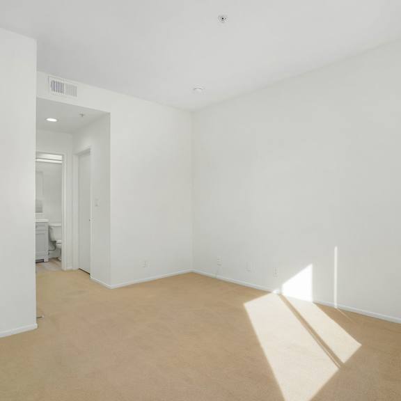 Thumbnail 27 of 29 A room with white walls and a light brown floor.