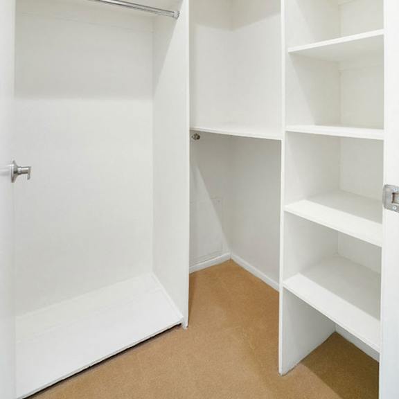 Thumbnail 29 of 29 A white closet with shelves and a door.