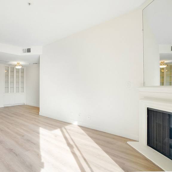 Thumbnail 23 of 29 A large, empty room with wooden floors and white walls.
