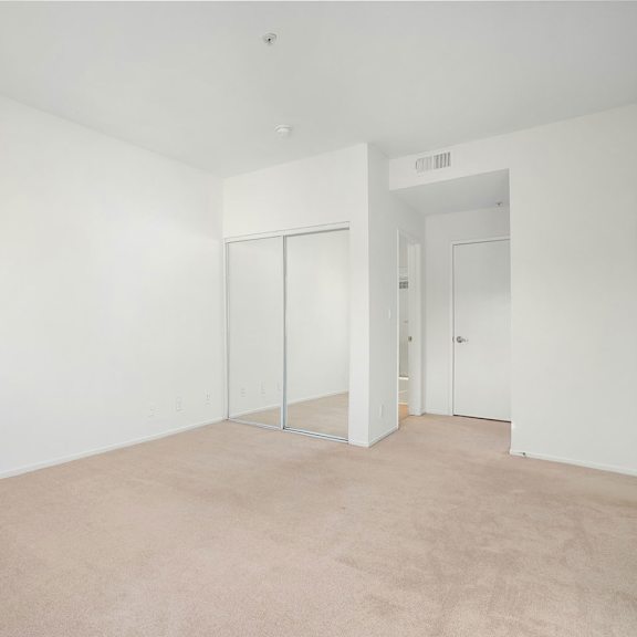 Thumbnail 21 of 29 A large empty room with white walls and carpeted floor.