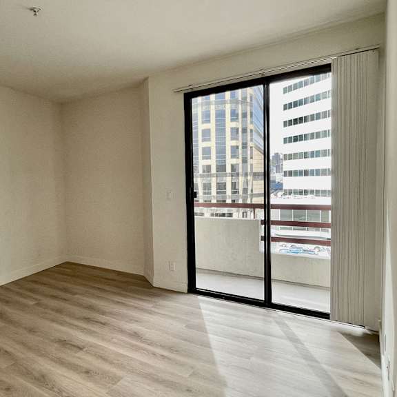 Thumbnail 12 of 26 A room with a sliding glass door leading to a balcony.