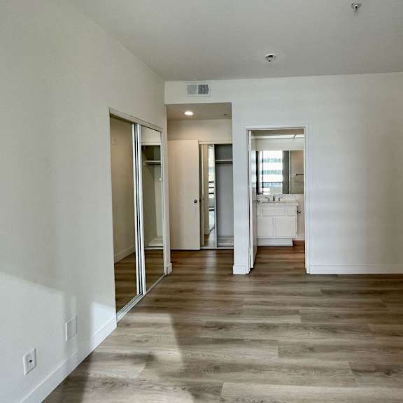 Thumbnail 14 of 26 A room with wooden flooring and white walls.